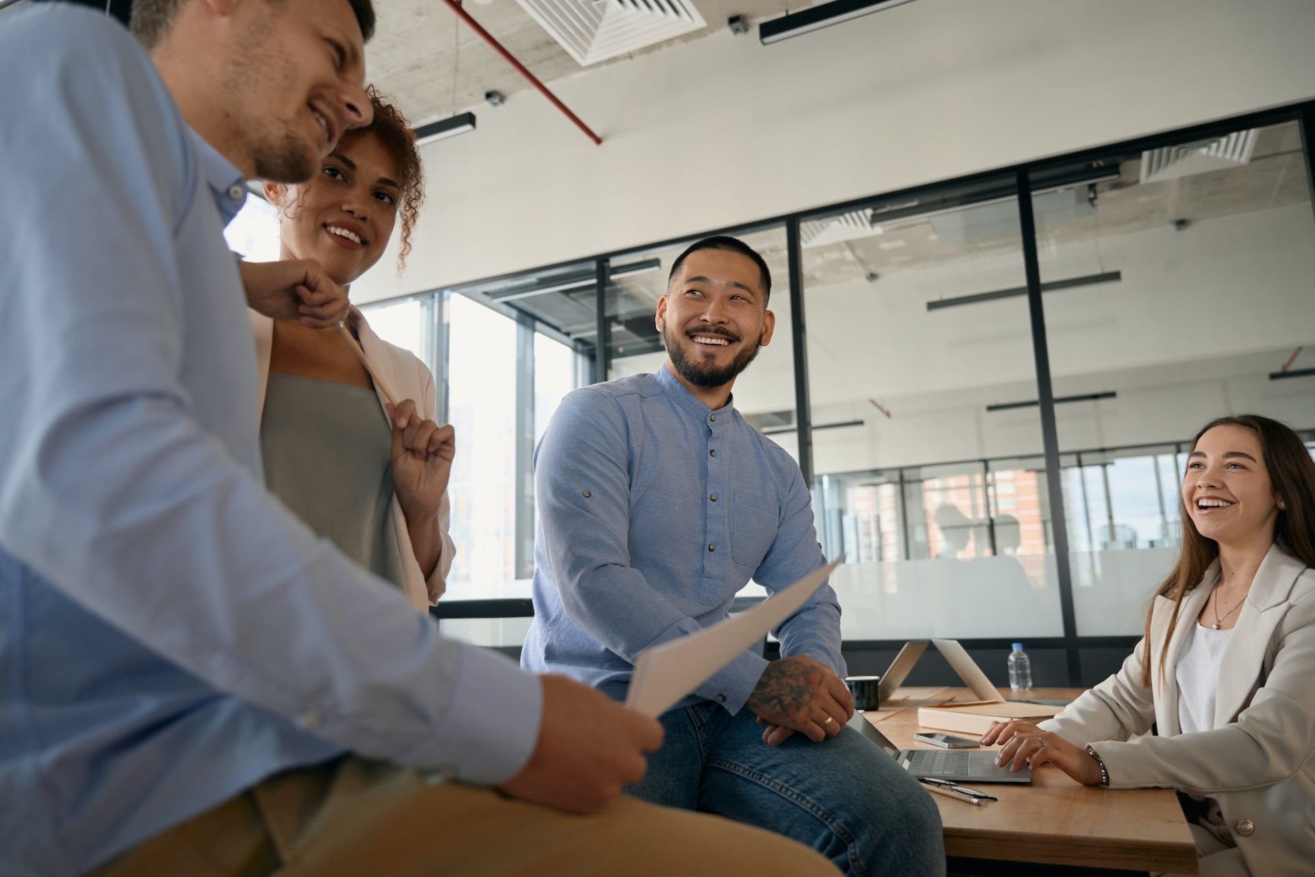 Team of employees chatting and laughing being in open office